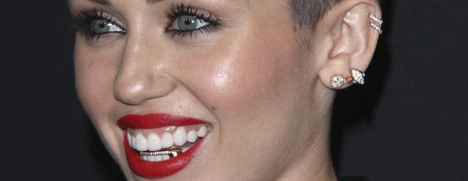 tooth gems Myley Cirus  wearing gold grillz